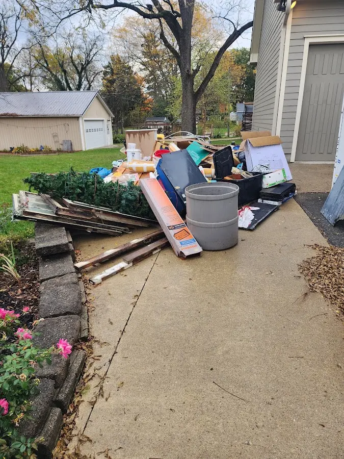 Dumpster being loaded with debris for 12 Yard Dumpster Rental in Liberty Triangle